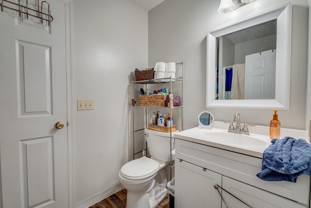 bathroom with hardwood / wood-style flooring, vanity, and toilet