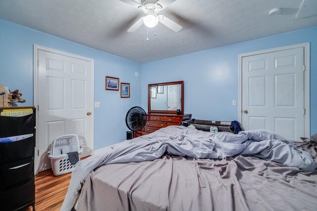 bedroom featuring ceiling fan, a textured ceiling, and light hardwood / wood-style flooring