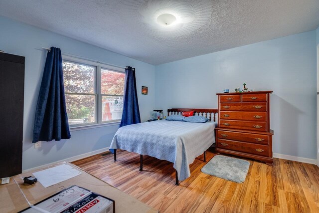 bedroom featuring a textured ceiling and light wood-type flooring