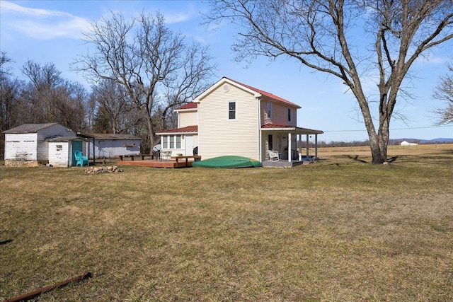 view of yard featuring a porch, an outdoor structure, a wooden deck, and a storage unit