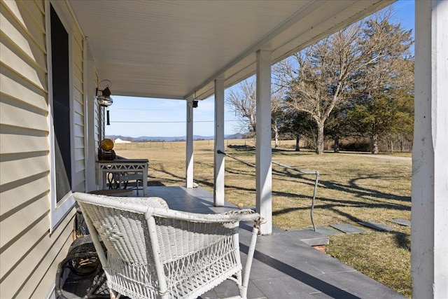 view of patio / terrace featuring a porch and a rural view