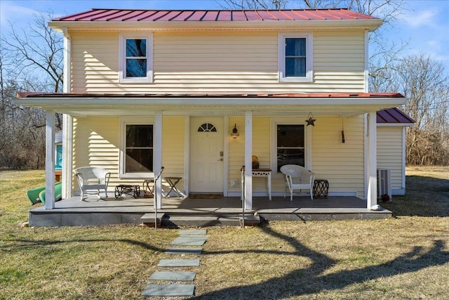 view of front of home featuring covered porch, a standing seam roof, metal roof, and a front yard