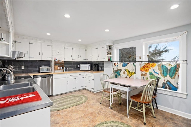 kitchen featuring white cabinetry, light countertops, stainless steel dishwasher, and open shelves