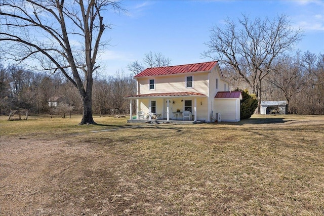 view of front of property featuring metal roof, a front lawn, a porch, and a standing seam roof