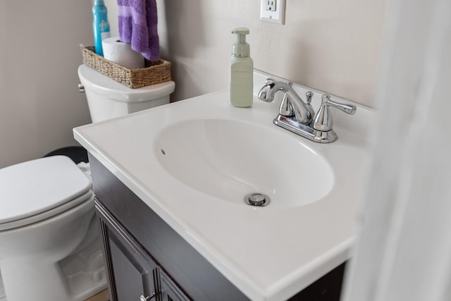 half bathroom featuring vanity and toilet