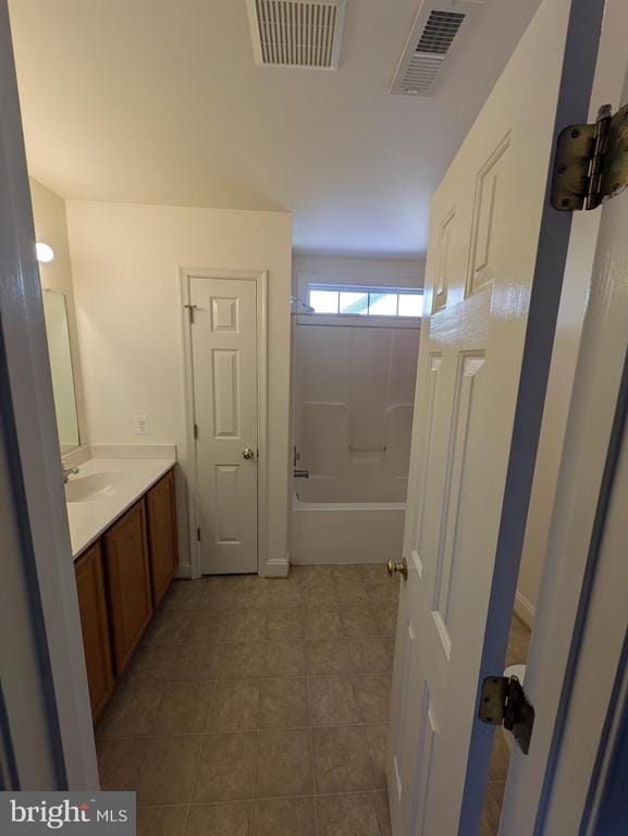 full bath with  shower combination, tile patterned flooring, visible vents, and vanity