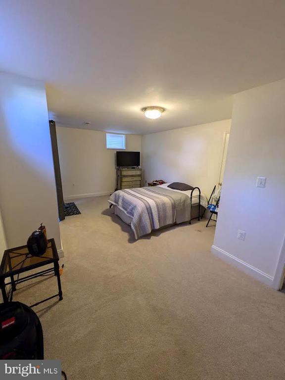 bedroom with baseboards and light colored carpet