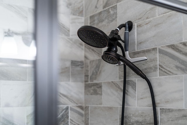 interior details featuring a tile shower