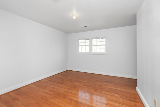 unfurnished room featuring light wood-style flooring, baseboards, and visible vents