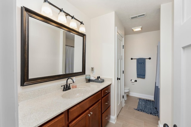 full bathroom with visible vents, toilet, vanity, and baseboards