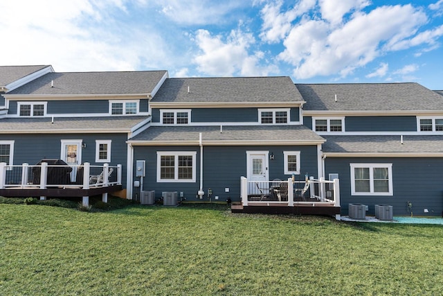 rear view of property featuring a lawn, cooling unit, and a deck