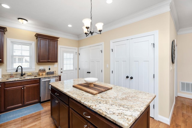 kitchen with light wood finished floors, visible vents, a chandelier, dishwasher, and a sink