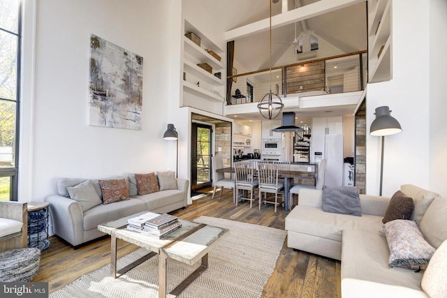 living room with plenty of natural light, a high ceiling, and wood finished floors