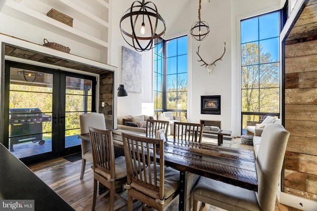 dining room featuring built in shelves, a wealth of natural light, french doors, a high ceiling, and dark wood-style flooring