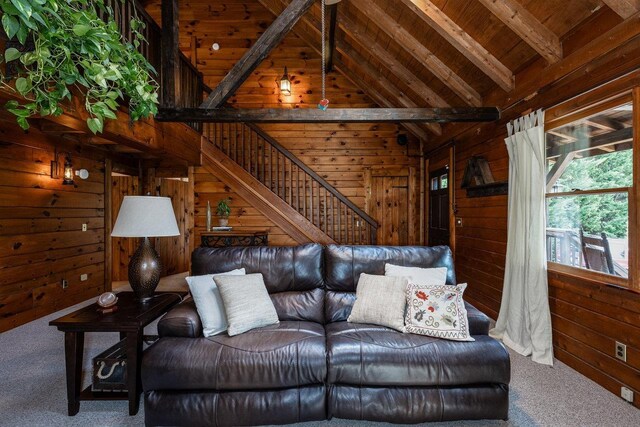 living room with high vaulted ceiling, wood walls, beamed ceiling, carpet, and wood ceiling