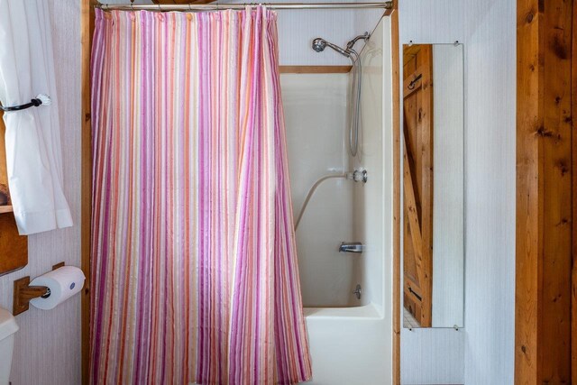 bathroom featuring toilet and shower / bath combo