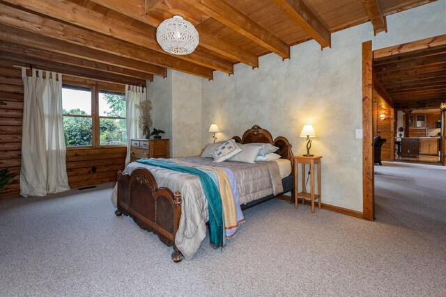 bedroom featuring beamed ceiling, carpet floors, and wooden ceiling