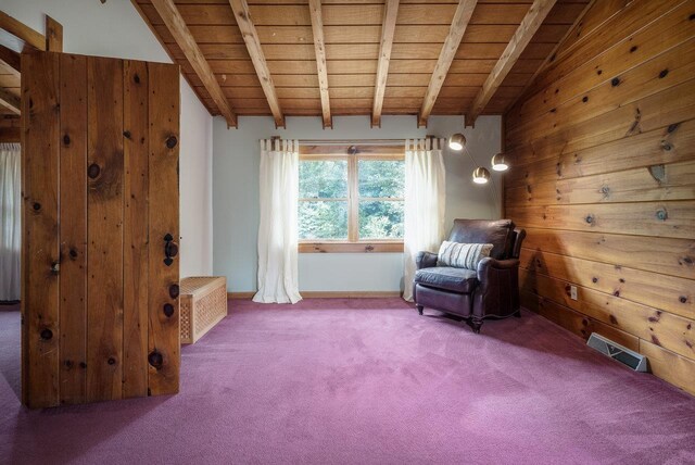 unfurnished room with wooden walls, lofted ceiling with beams, wooden ceiling, and carpet