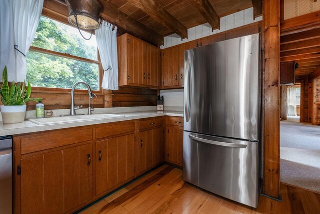 kitchen featuring sink, stainless steel appliances, wooden ceiling, beam ceiling, and light hardwood / wood-style flooring