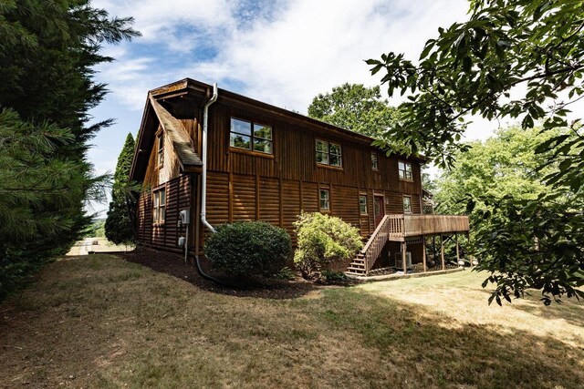 view of home's exterior with a wooden deck and a yard