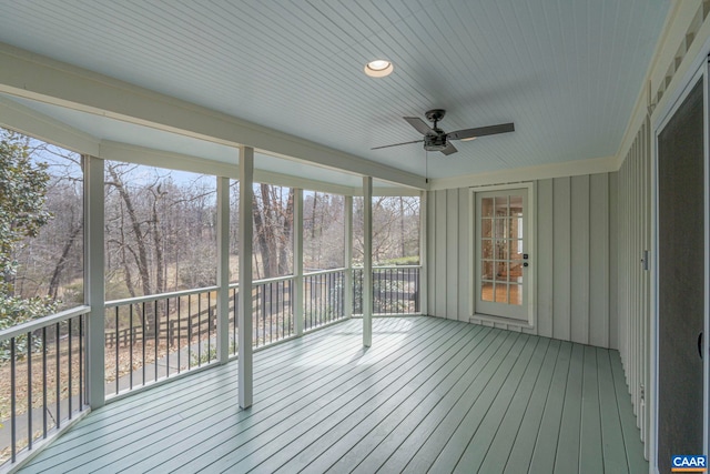 unfurnished sunroom featuring a ceiling fan and a healthy amount of sunlight