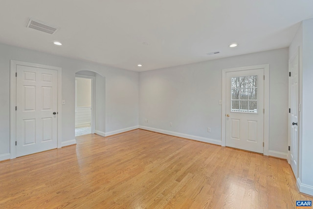 spare room with light wood-style flooring, visible vents, arched walkways, and recessed lighting