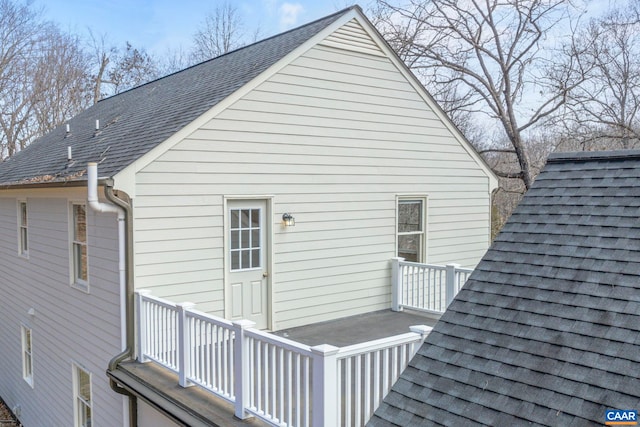 rear view of house with a shingled roof and a wooden deck