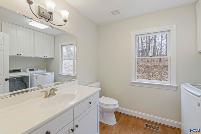 bathroom featuring toilet, washer / dryer, and visible vents