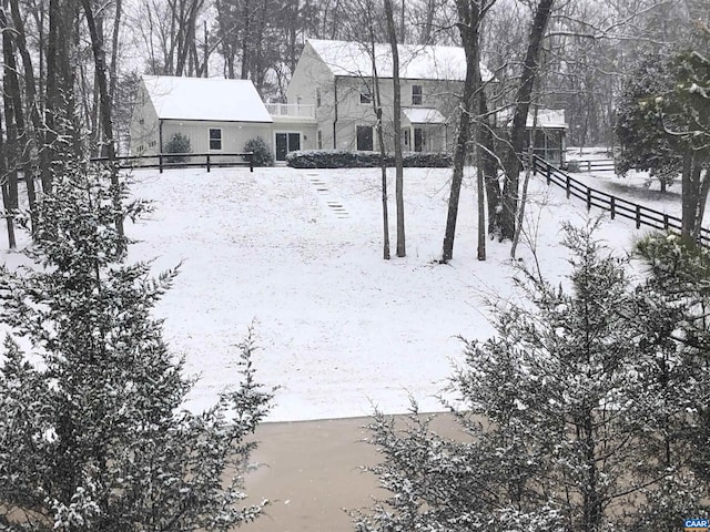 yard covered in snow featuring fence