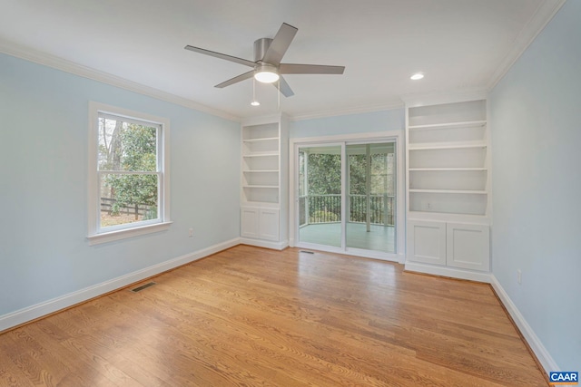 spare room with plenty of natural light, baseboards, and light wood-style flooring