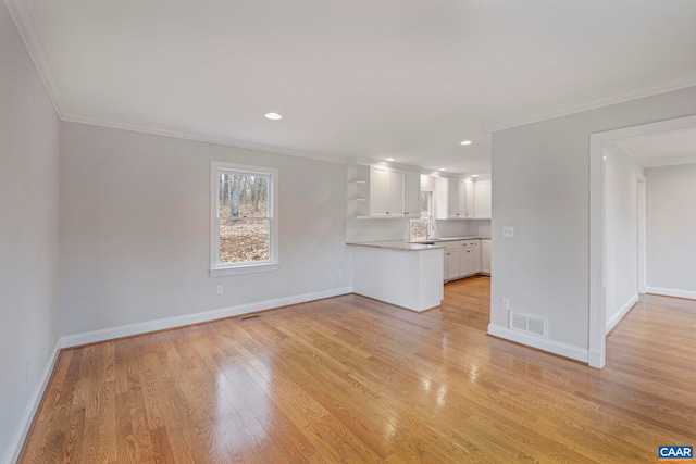 unfurnished living room with recessed lighting, visible vents, baseboards, light wood-style floors, and ornamental molding