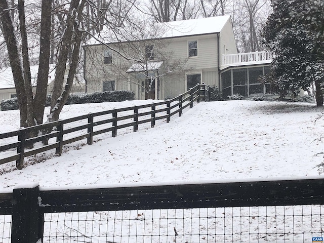 snow covered property featuring fence