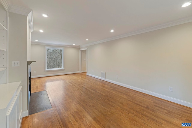 unfurnished living room featuring ornamental molding, light wood finished floors, and visible vents