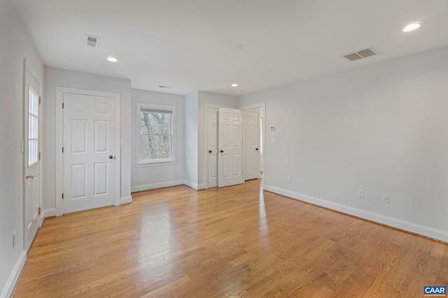 interior space featuring light wood-style floors, visible vents, and baseboards