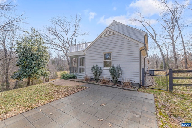 view of side of home featuring fence and a gate