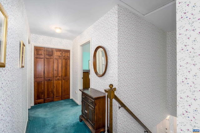 hall featuring wallpapered walls and carpet