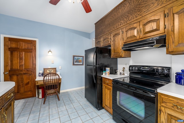 kitchen featuring black appliances, brown cabinetry, light countertops, and under cabinet range hood