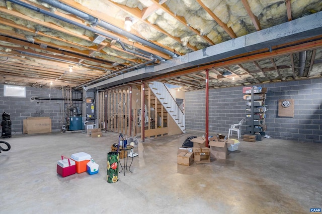 basement with heating unit, a heating unit, and stairs