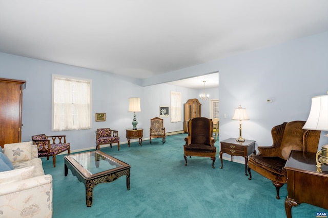 carpeted living area featuring baseboards and a chandelier