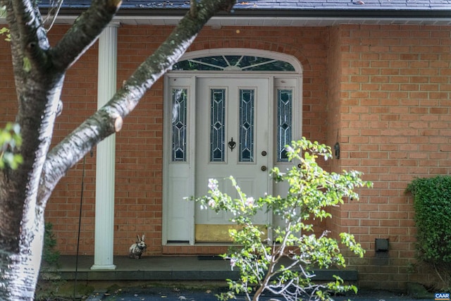 view of exterior entry with brick siding