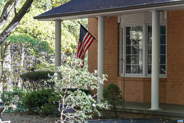 view of home's exterior with brick siding and roof with shingles