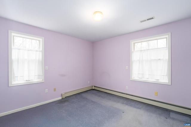 carpeted empty room featuring visible vents, plenty of natural light, baseboards, and a baseboard heating unit