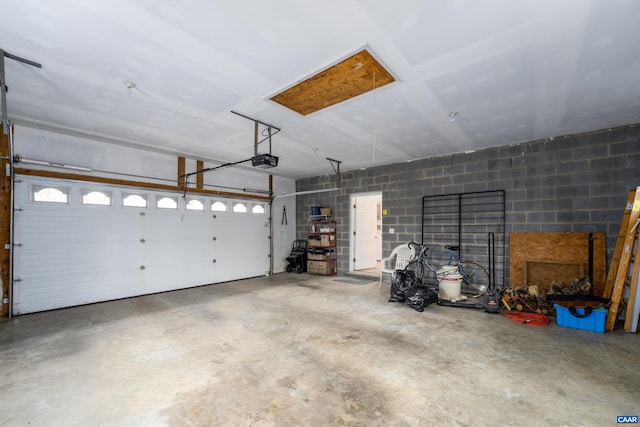 garage featuring a garage door opener and concrete block wall