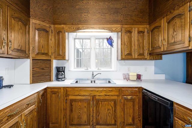 kitchen with a sink, brown cabinets, black dishwasher, and light countertops