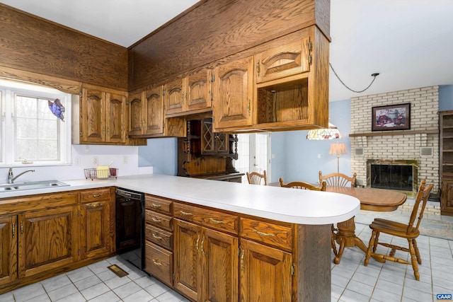 kitchen featuring a sink, a brick fireplace, dishwasher, and light countertops