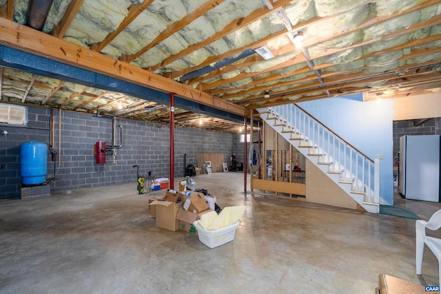 unfinished below grade area with stairway and freestanding refrigerator