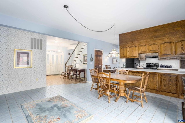 dining area featuring stairs, light tile patterned floors, visible vents, and wallpapered walls