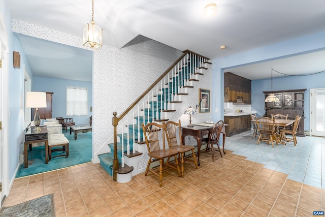 dining room with wallpapered walls, tile patterned floors, stairway, and a chandelier