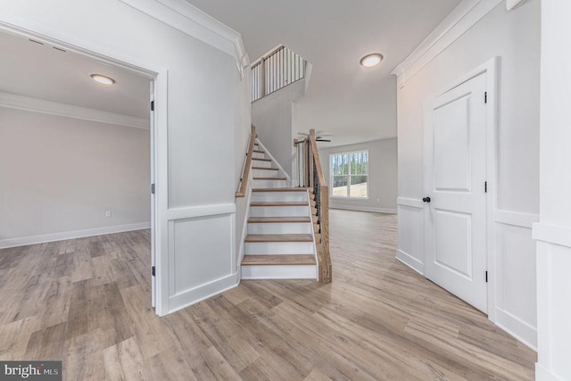 stairs with hardwood / wood-style flooring and ornamental molding