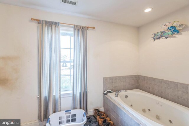 bathroom with a whirlpool tub and visible vents